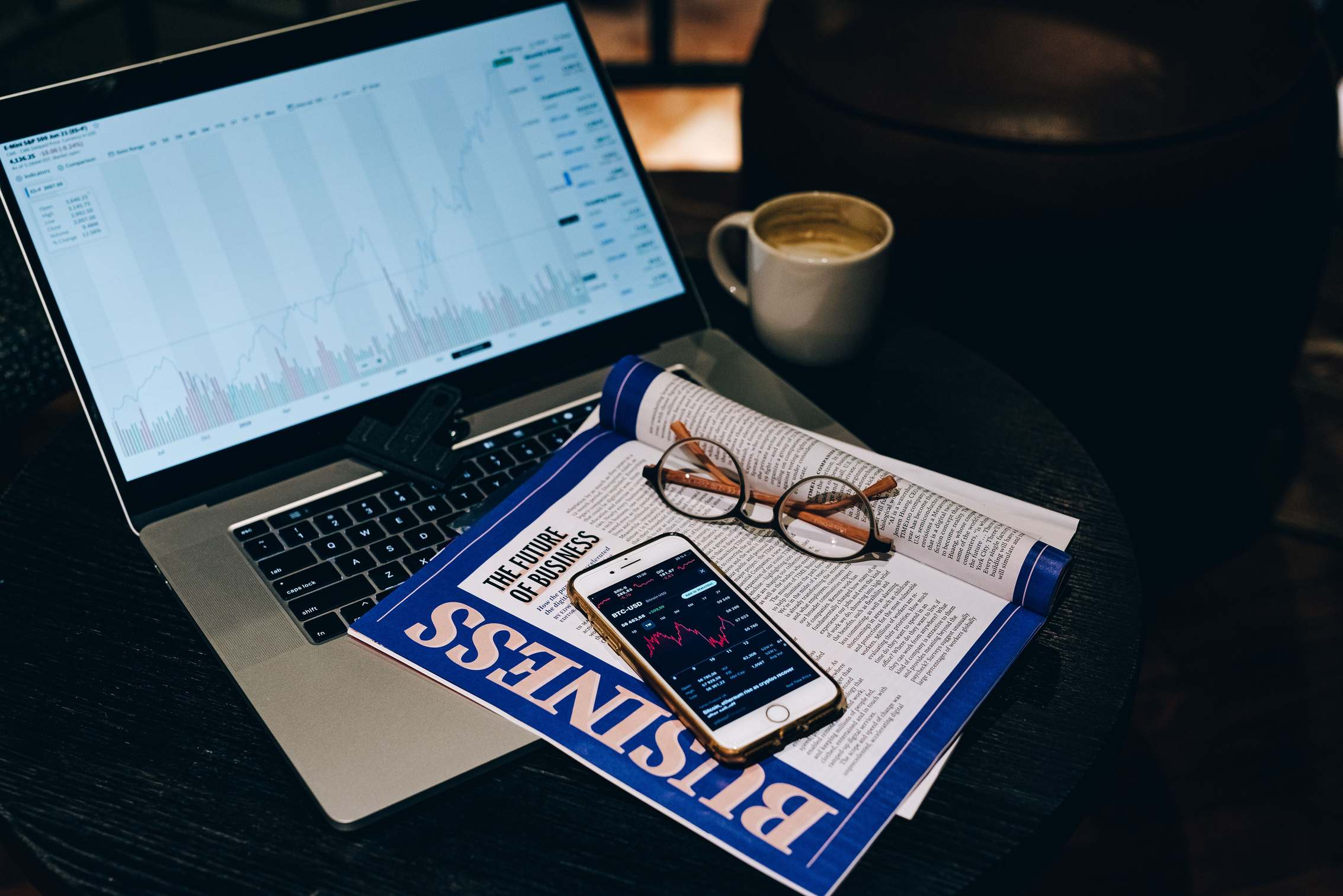 Professional workspace with laptop, smartphone, and business materials on a table